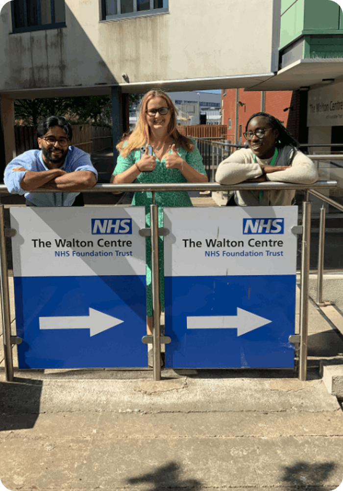 3 people stood outside The Walton Centre