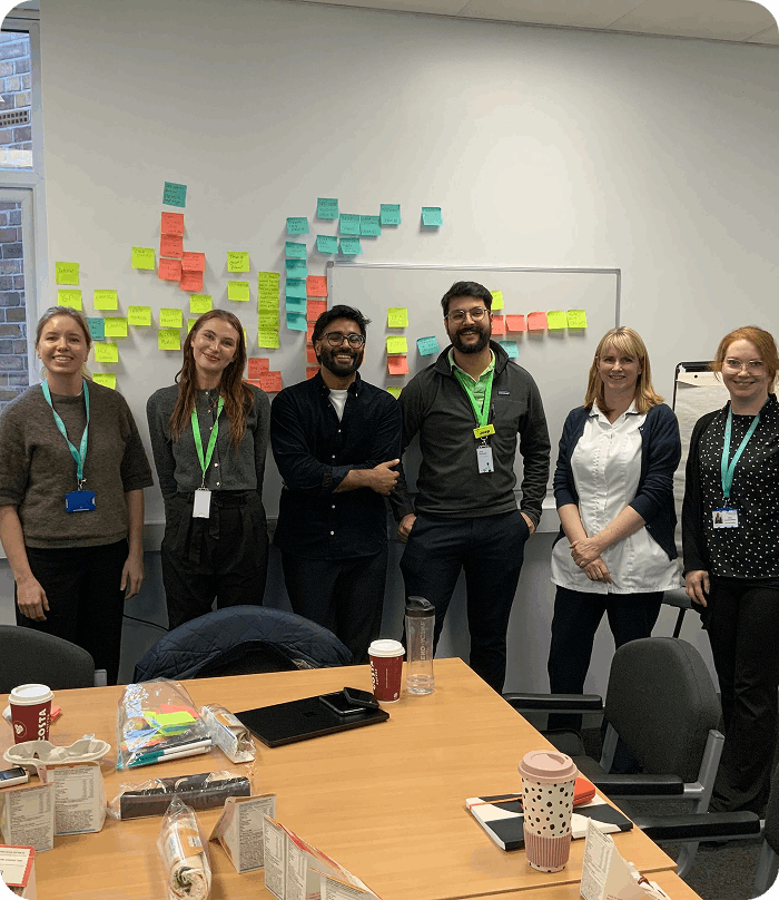 6 people standing in front of whiteboard