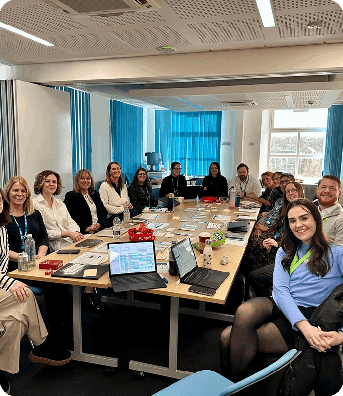 Group of people sat round board room table